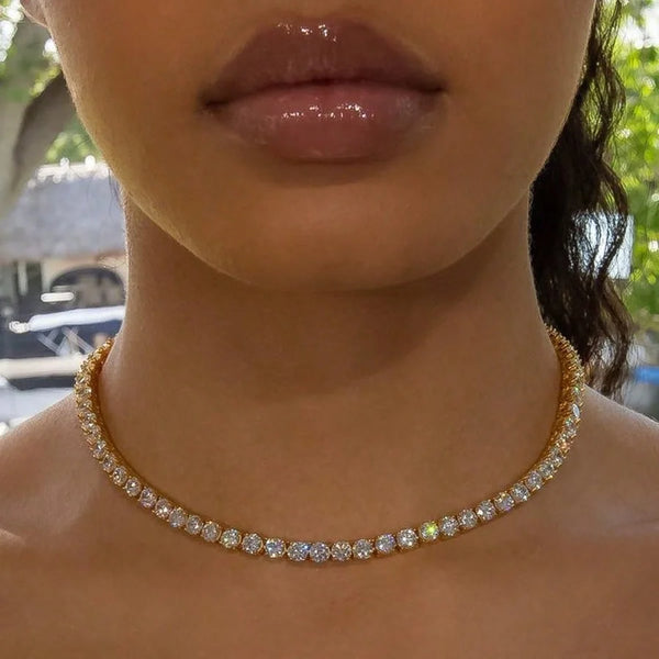 Nahaufnahme einer Frau mit einer goldenen Statement-Strasskette um den Hals.