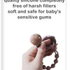 A hand is holding a silicone pacifier clip with a teether, showing the product for baby's sensitive gums.