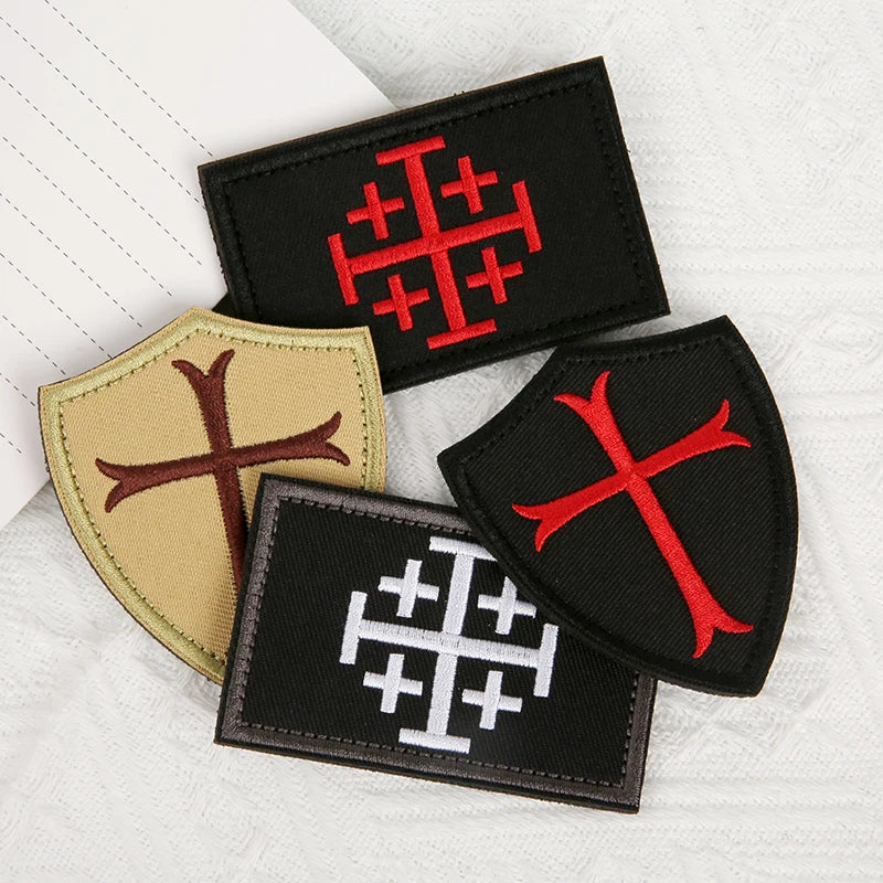Three embroidered patches featuring the Knights Templar cross design on black and tan fabric.