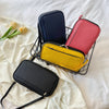 A black waterproof document organizer wallet and three colored passport holders are displayed on a white sheet.