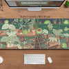 A large extended desk mat featuring a kawaii frog and nature design on a wooden surface.