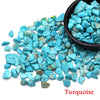 A pile of bright blue turquoise crystal stone chips in a black bowl.