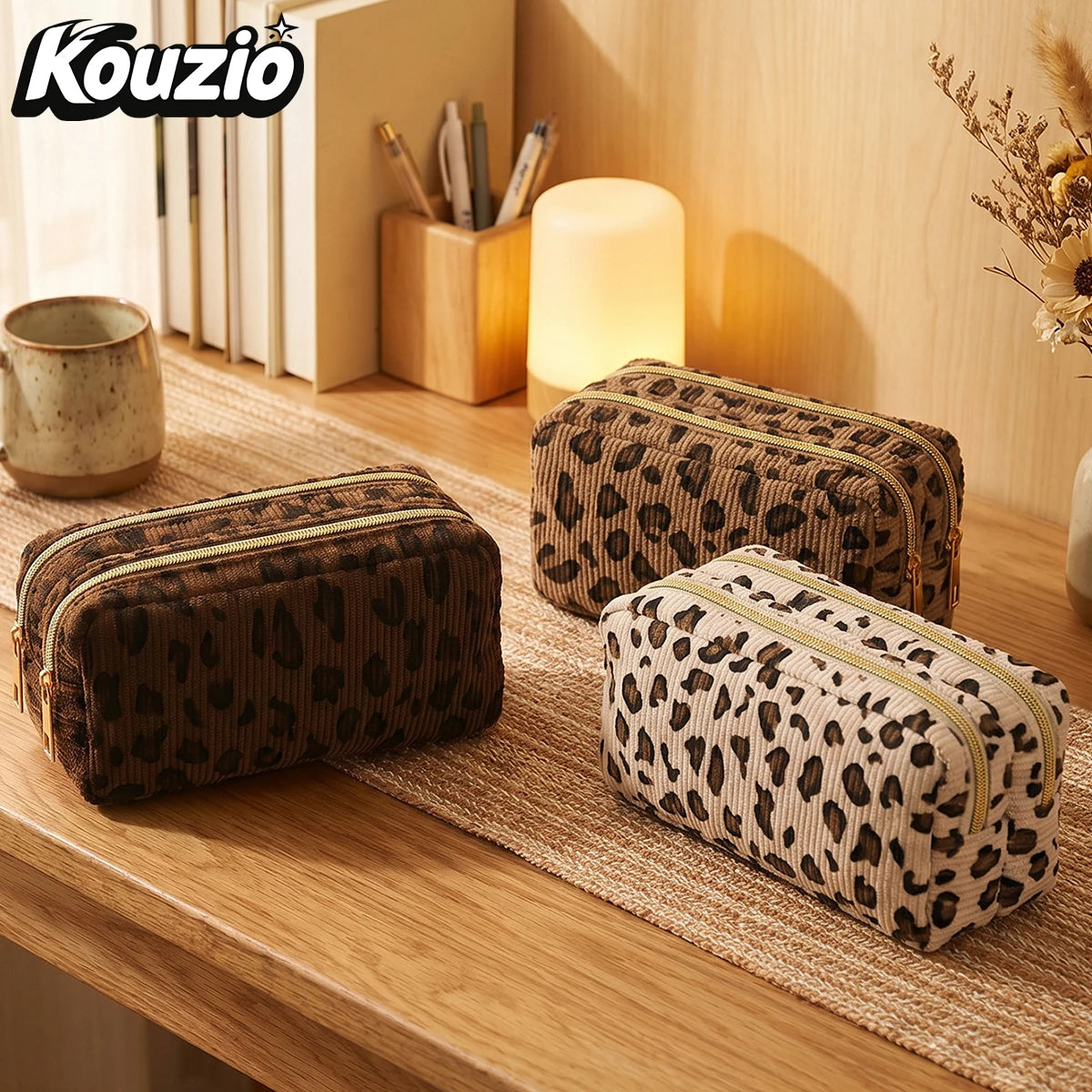 A brown leopard print double-zip pencil case resting on a wooden surface next to a glowing lamp.