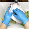 Hands wearing blue nitrile disposable gloves are placing a dark object into a white rectangular dish in a sink.