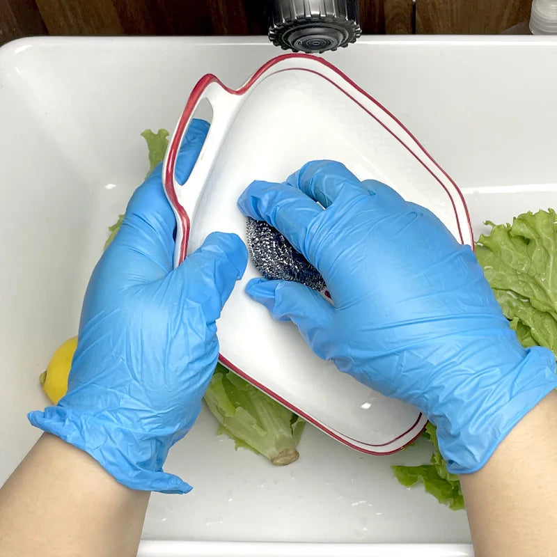 Hands wearing blue nitrile disposable gloves are placing a dark object into a white rectangular dish in a sink.