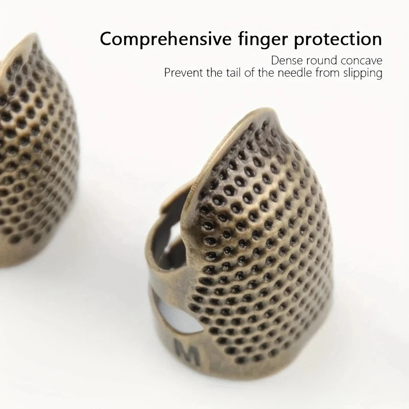 A close-up view of a vintage metal sewing thimble with a dense round concave finger protection ring.