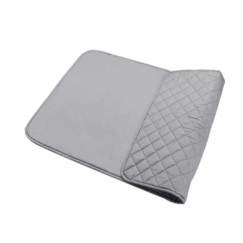 A gray heat-resistant portable ironing mat with a quilted section.