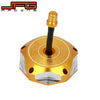 A gold-colored aluminum motorcycle fuel tank cap with a black threaded fitting and an engraved logo.