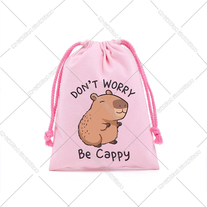 Pink drawstring storage bag featuring a cute capybara illustration with the text Don't Worry Be Cappy