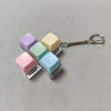 A keychain featuring five colorful, translucent mechanical keyboard fidget cubes attached to a silver keyring.