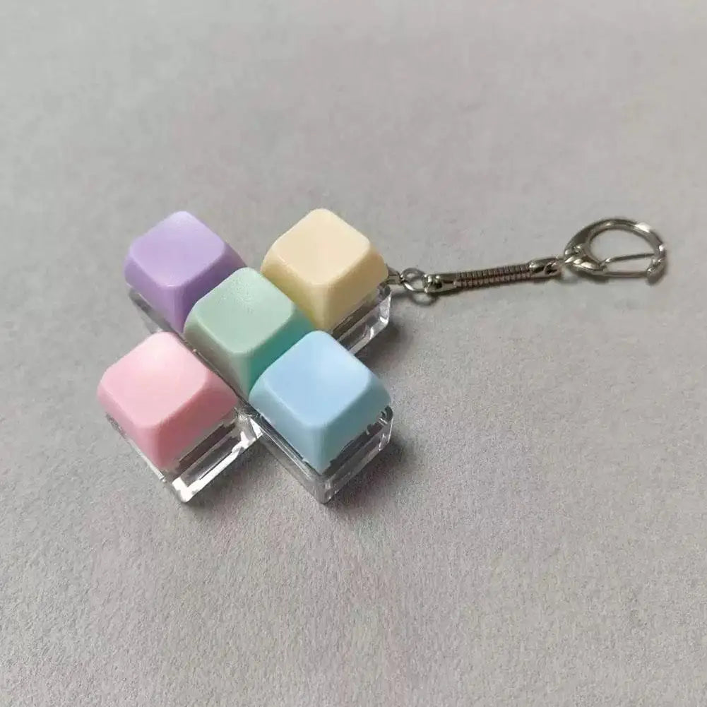 A keychain featuring five colorful, translucent mechanical keyboard fidget cubes attached to a silver keyring.