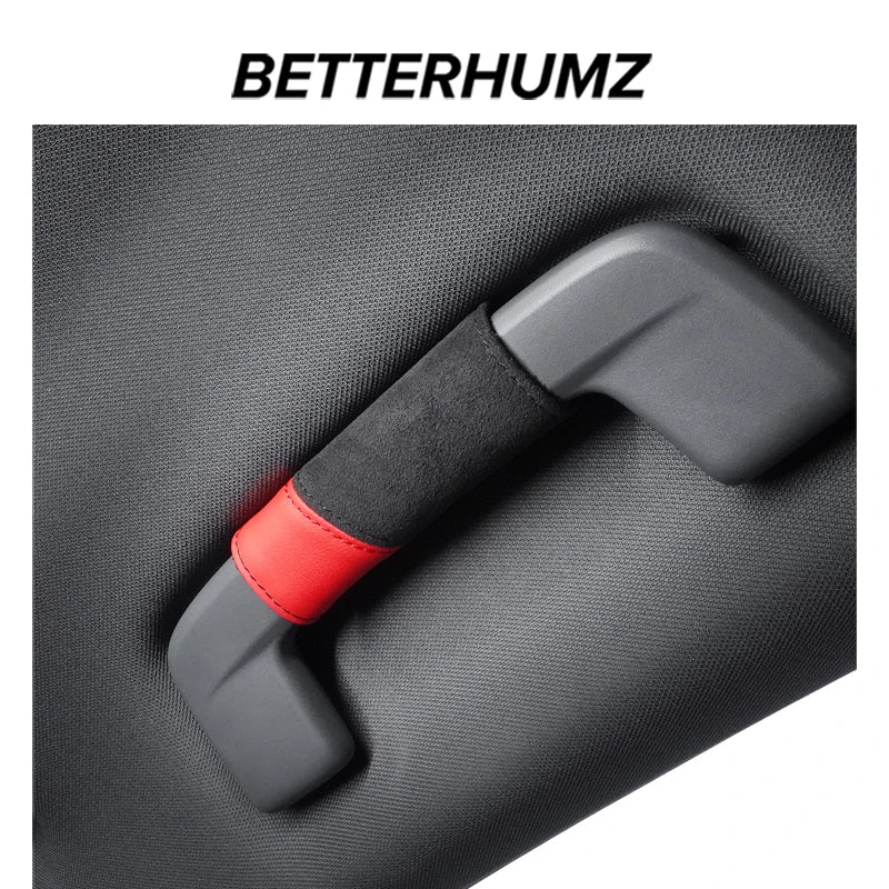 A close-up of a gray grab handle protector cover with a red accent on a dark fabric surface.