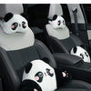 A white and black panda plush cushion is placed on a car seat headrest.