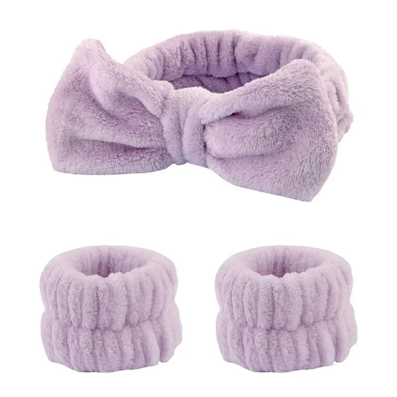 A lavender fuzzy wrist washing band shown in three views: a folded bow and two circular cuffs.