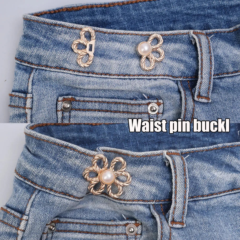 Close-up of a denim jean waistband featuring decorative gold and pearl waist pin buckles.