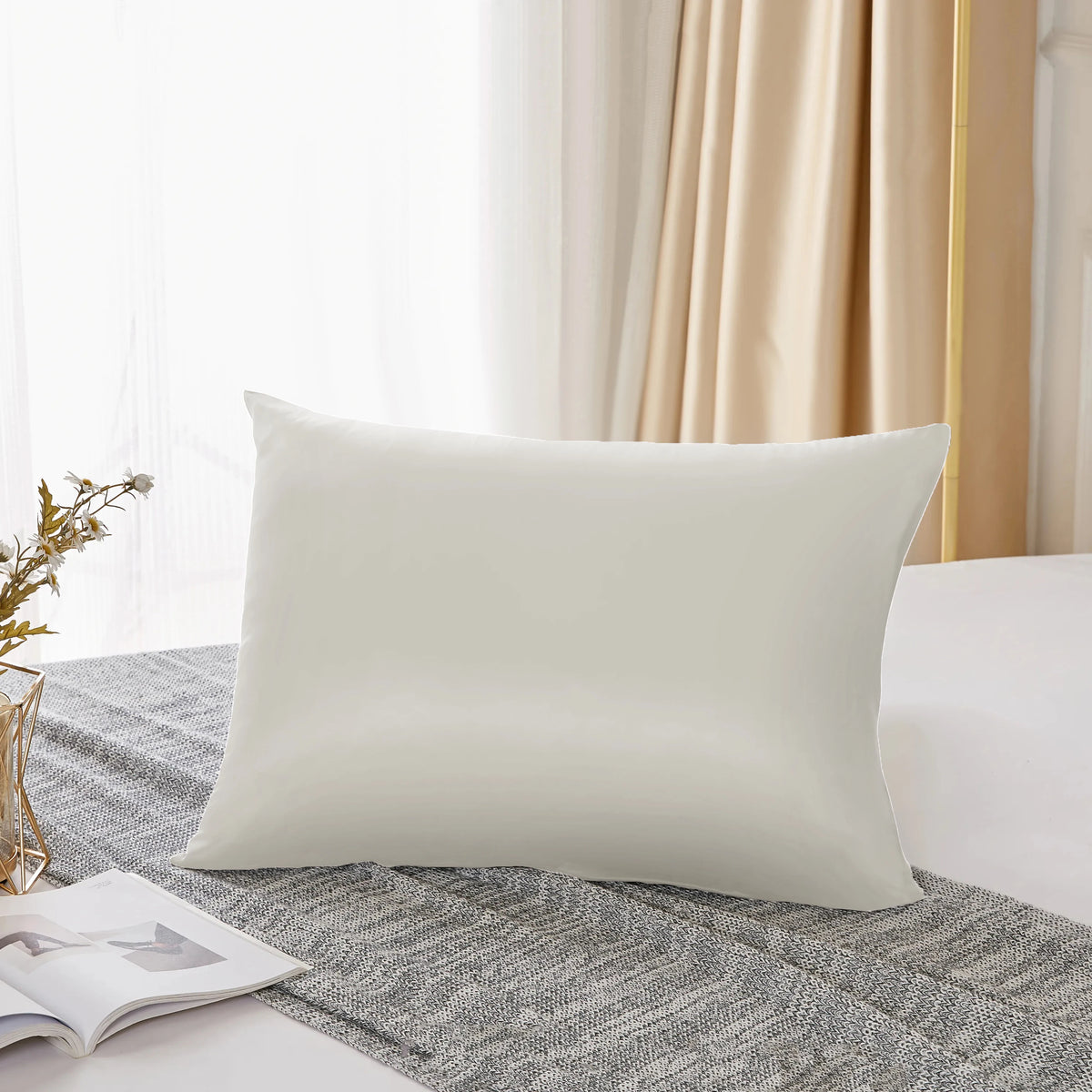 Housse de couette en soie de mûrier naturelle blanche posée sur un tissu en lin gris dans une pièce lumineuse.