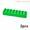 A green plastic building block set with 12 pieces, shown from the side.