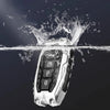 A protective key fob cover floating above water, showing a silver and black device splashing water.