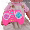 A pink silicone game controller toy is being held by a baby wearing a light pink dress.