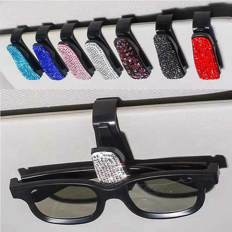 A display of various colored crystal rhinestone sunglasses clips arranged in a row.
