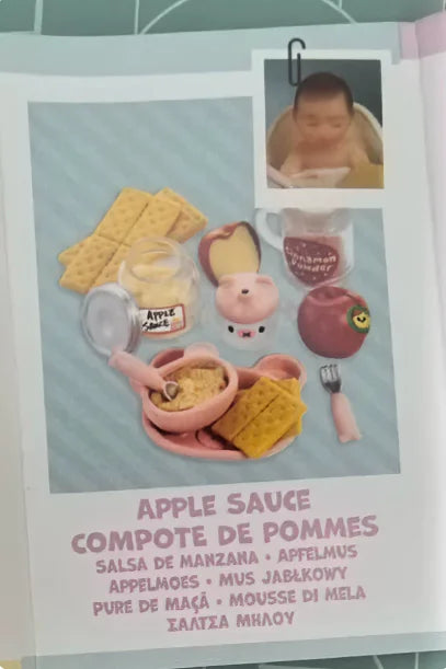 Miniature food accessories for a baby doll kit including apple sauce and other foods