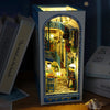 A DIY book nook kit featuring a miniature room scene with wooden shelves and decorative elements.