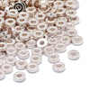 A pile of small, round silver-colored acrylic spacer beads for jewelry making.