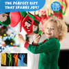 A smiling young child holds a green Christmas-themed parachute toy with colorful figures against a blurred festive background