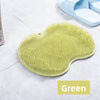 A green suction cup foot massage mat with exfoliating bristles is shown on a white surface.