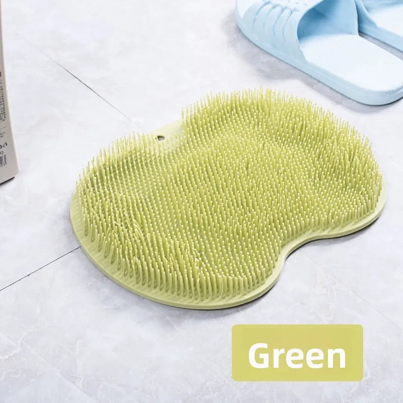 A green suction cup foot massage mat with exfoliating bristles is shown on a white surface.
