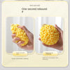 A hand is squeezing a yellow soft mesh bath sponge ball, demonstrating its rebound property.