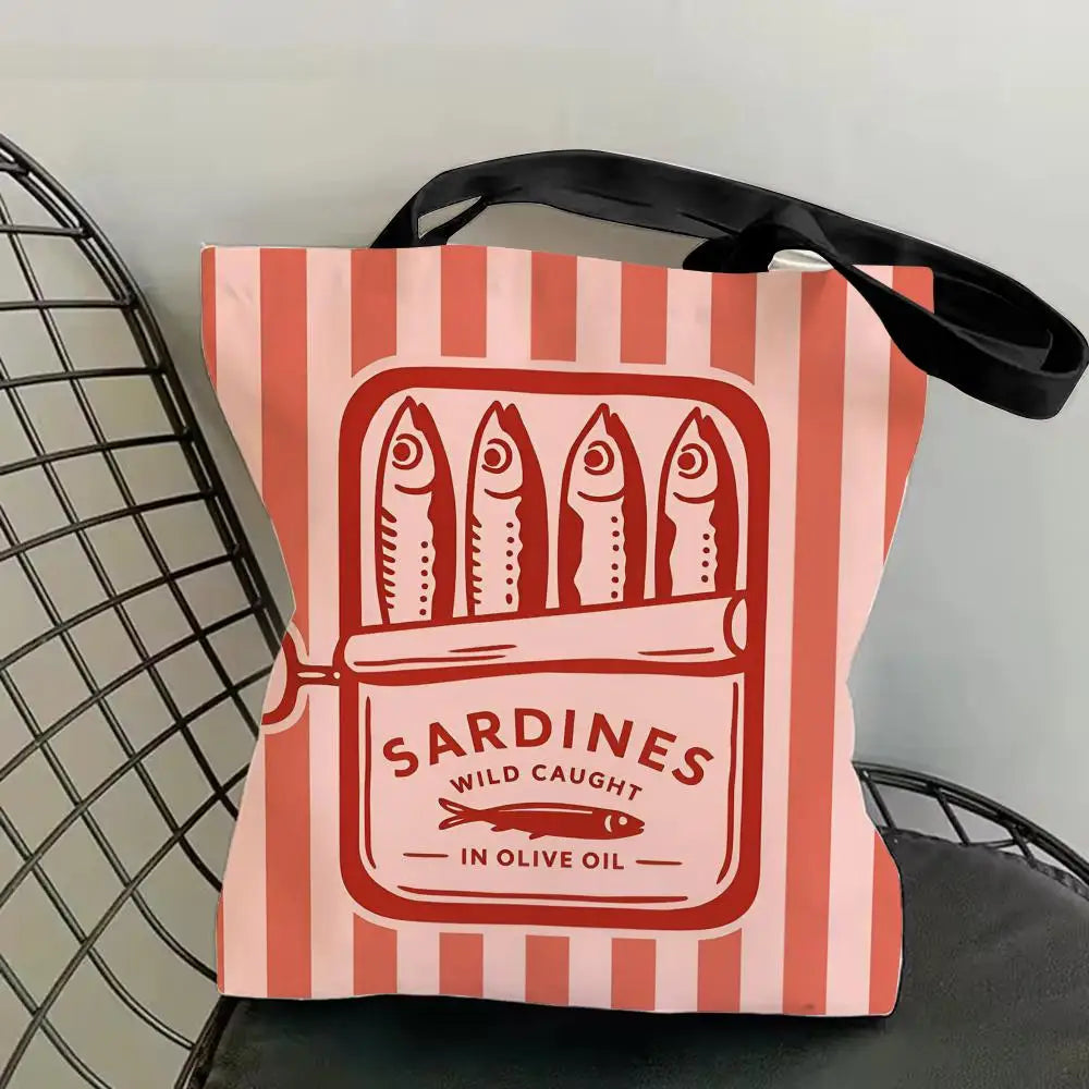 A pink and orange striped canvas tote bag featuring a graphic print of sardines in olive oil.