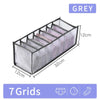 A grey foldable closet organizer box with seven grids for storing underwear, socks, and accessories.
