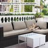 Beige L-förmiges Outdoor-Sofa mit Glas-Couchtisch und umgebender Grünpflanzen