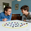 Zwei junge Männer lächeln, während sie ein magnetisches Schachspiel auf einem weißen Tisch spielen.