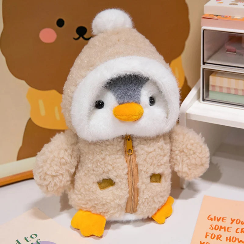 A fluffy beige penguin plush toy wearing a white hat and orange feet.