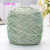 A ball of light green metallic silk crochet yarn with silver shimmer thread for knitting and macrame.