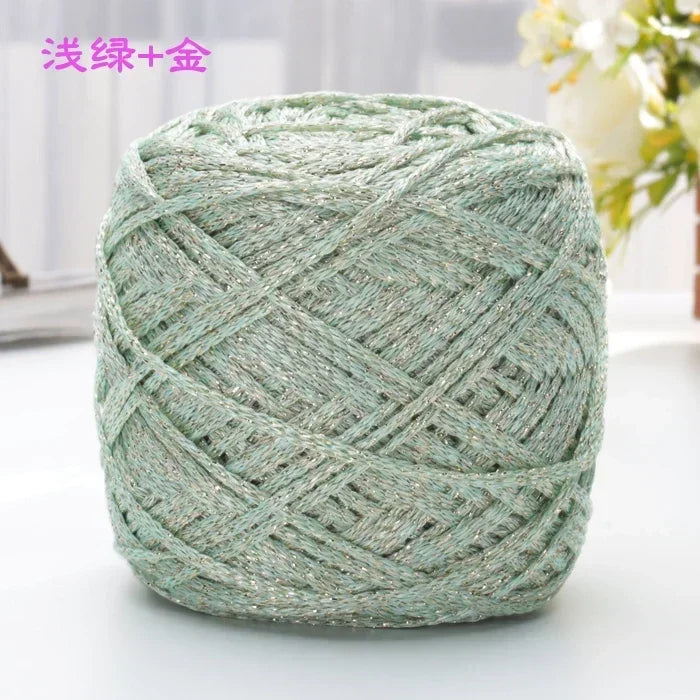 A ball of light green metallic silk crochet yarn with silver shimmer thread for knitting and macrame.