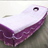 Purple disposable bed sheets with white trim and a circular hole, laid out on a floor.
