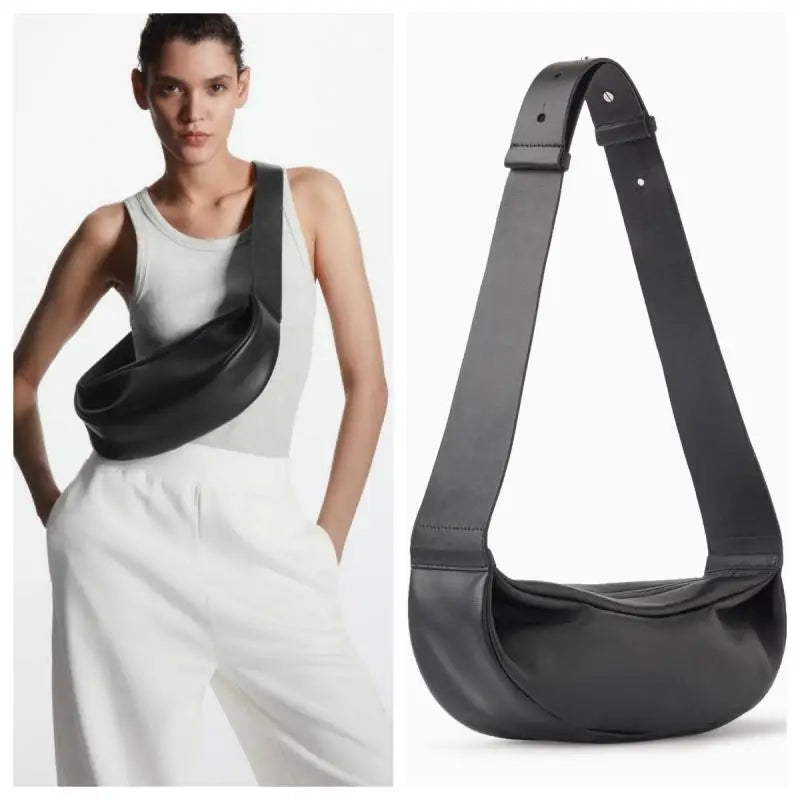 Schwarze, echte Leder-Crossbody-Tasche, getragen von einem Model in weißem Oberteil und Hose.
