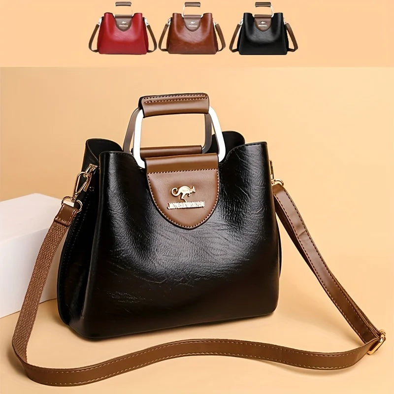 A black leather vintage crossbody tote bag with a brown strap and a gold-toned logo detail.