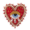 A heart-shaped patch made of red fabric and adorned with sparkling beads, rhinestones, and a gold eye design.