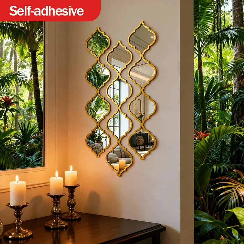 Gold-framed decorative mirror wall stickers displayed on a white wall next to potted plants.