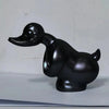 A glossy black resin duck hood ornament for a car or motorcycle.
