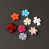 A collection of silicone nail art molds shaped like 3D flowers in various colors including orange, blue, white, pink, and pur