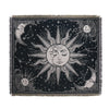 A dark fabric throw blanket featuring a celestial design with stylized suns and moons.