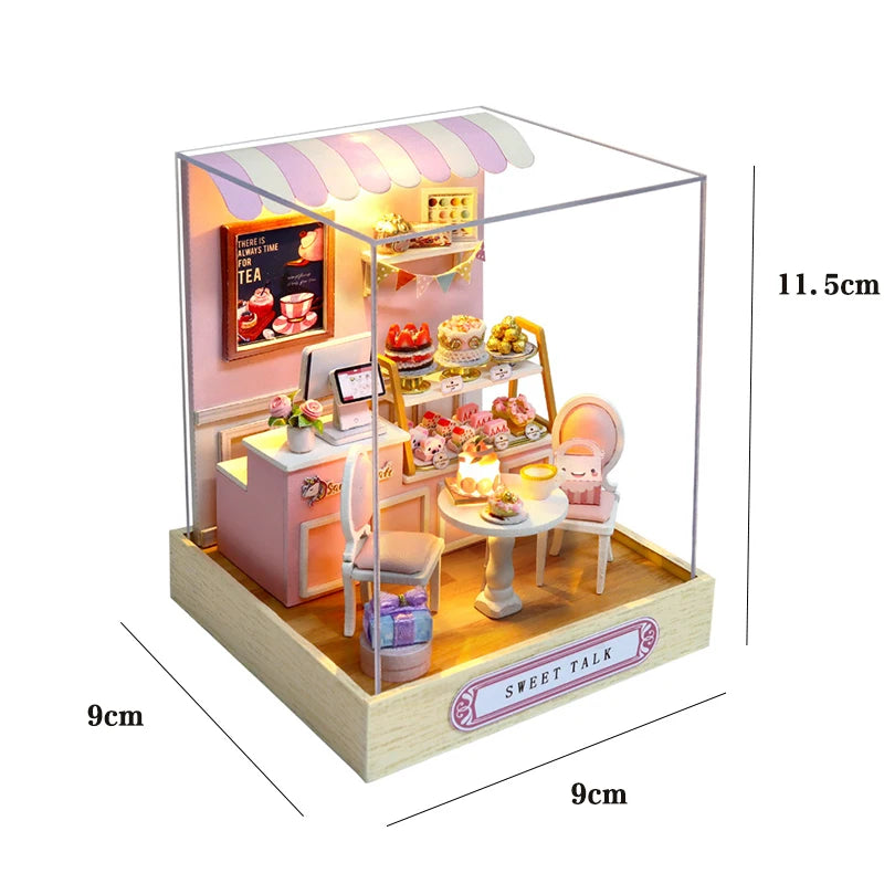A miniature wooden dollhouse assembly kit featuring a pink and white cafe facade with LED lighting and small furniture.