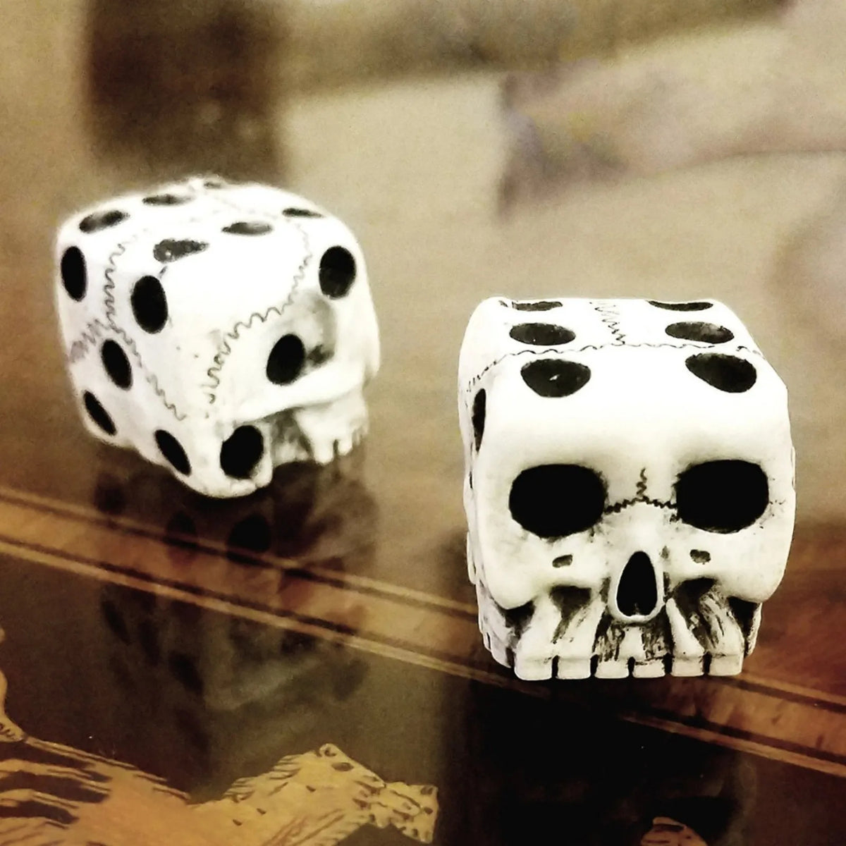 A set of white gothic skull dice resting on a dark wooden surface.