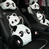 A row of panda plush car headrests and lumbar support cushions in black and white on a car seat.
