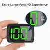 A hand holds a black speedometer device displaying 100 Km/h on a green LED screen.